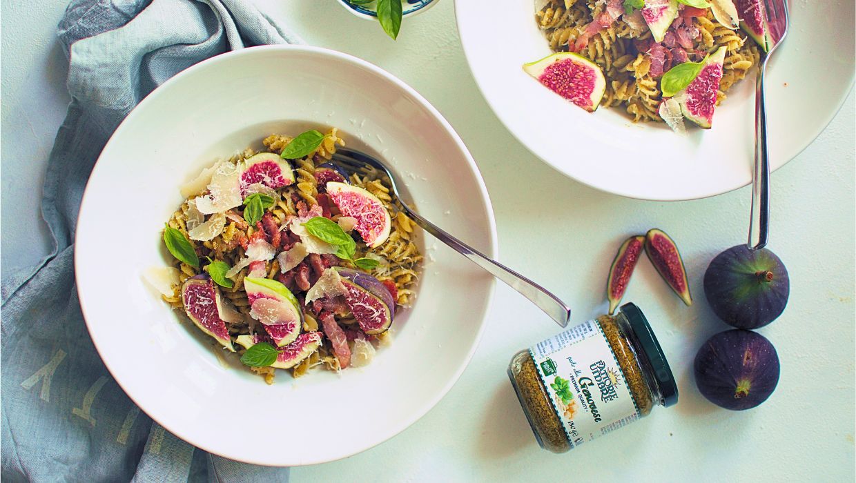 Makaron z pesto genovese i figą na talerzu z parmezanem i bazylią